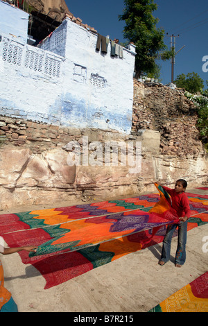 Indianerjunge und lokalen Textilien in der Sonne mit blau lackierten Brahmane Traditionshaus in der alten Stadt jodhpur Stockfoto