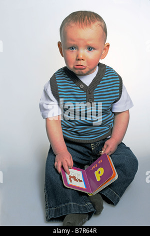 Unglückliche junge Alphabet Buch lesen Stockfoto