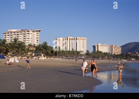 Besucher schlendern Palmar Playa, Ixtapa/Zihuatanejo, Guerrero, Mexiko. Stockfoto