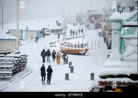 Walkers promenade entlang Brighton Seafront während eines Schneefalls UK Stockfoto