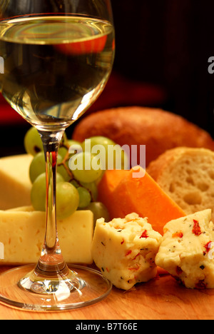 Glas Weißwein und verschiedene Käsesorten für eine Weinprobe Stockfoto