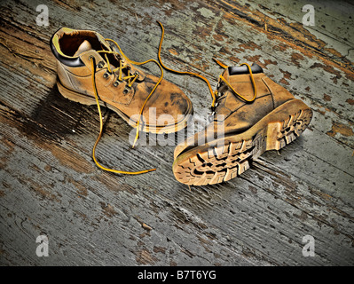 Alten schmutzige Arbeitsstiefel auf schmutzigen Boden Stockfoto