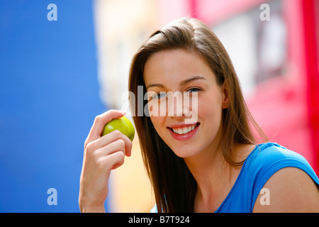 Junge Frau, die einen gesunden Snack einen Apfel zu essen Stockfoto