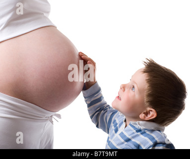 Kleiner Bruder niedliche kleine Junge im Gespräch mit seiner schwangeren Mutter Studio gedreht isolierten auf weißen Hintergrund Stockfoto