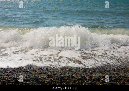 Wellen, die auf Kiesstrand Stockfoto