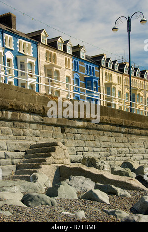 Reihenhäuser am Meer mit ihrer farbenfrohen Darstellung auf der Victoria Terrace, aufgenommen vom Strand in Aberystwyth, Wales. Stockfoto