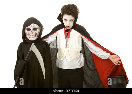 Zwei jungen als ein Vampir und der Sensenmann isoliert auf weiß für Halloween verkleidet. Stockfoto