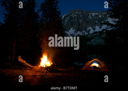 ein Mann sitzt auf einem Campingplatz in der Nacht vor einem Lagerfeuer an Alta Seen, colorado Stockfoto