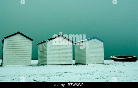 Strandhütten und Fischerboot im Schnee Stockfoto