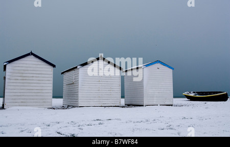 Strandhütten und Fischerboot im Schnee Stockfoto