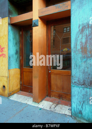 Eine Reihe von Holztüren mit Glasfenstern auf einem gesperrten, ungenutzte Gebäude durchläuft, Umbau in Manhattan, New York. Stockfoto