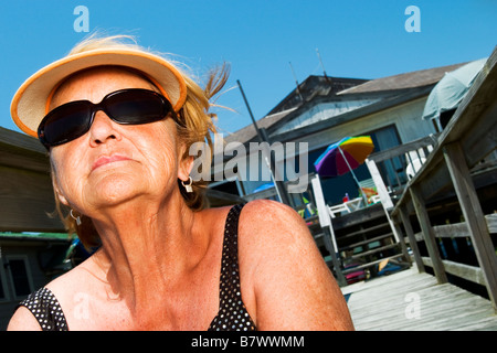 Frau sitzt auf der Treppe im Beach House bekommen eine tan Stockfoto