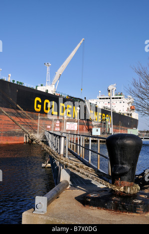 [Kraftstofftanker] angedockt am Pier zeigt Schlauch Umgang mit Kran für die Auslagerung von Öl- und Festmacher Poller gesichert Stockfoto