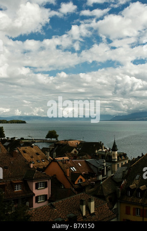 Der Blick von oben von Nyon in der Schweiz mit Blick auf den Genfer See mit bewölktem Himmel und Berge im Hintergrund. Stockfoto