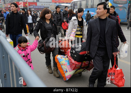 Migrantische ArbeiterInnen tragen ihr Gepäck verlassen den Bahnhof von Nanchang, Jiangxi, China. 5. Februar 2009 Stockfoto