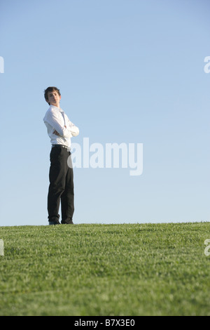 Ein Business-Mann stehend auf einem Rasen-Hügel Stockfoto