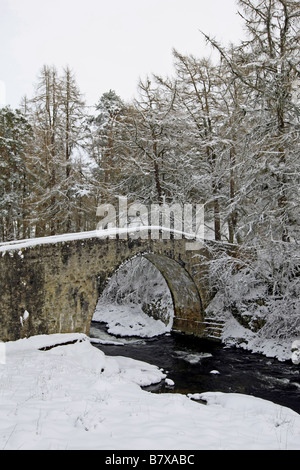 Alten Spannweite der Poldhullie Brücke über den Fluss Don in Strathdon, Aberdeenshire, Schottland, im Winter mit Schnee bedeckt. Stockfoto