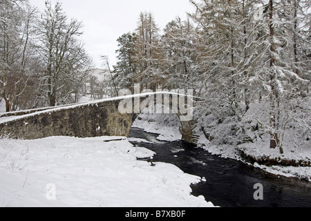 Alten Spannweite der Poldhullie Brücke über den Fluss Don in Strathdon, Aberdeenshire, Schottland, im Winter mit Schnee bedeckt. Stockfoto