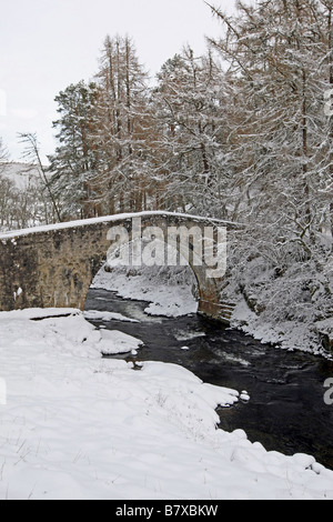 Alten Spannweite der Poldhullie Brücke über den Fluss Don in Strathdon, Aberdeenshire, Schottland, im Winter mit Schnee bedeckt. Stockfoto