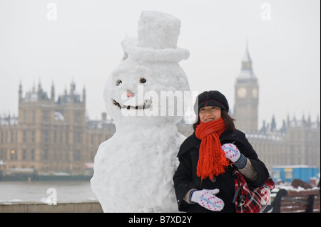 Touristen, posiert mit Schneemann auf Albert Embankment London Vereinigtes Königreich Stockfoto