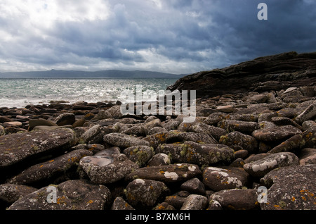 Felsige Bucht mit Blick auf Raasay von Applecross, Nord-West-Schottland mit dramatischen Gewitterhimmel Stockfoto