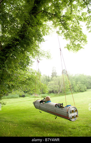 Kleiner Junge fliegt um in einem Raumschiff an einem Baum hängen. Stockfoto