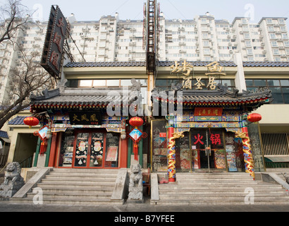 Der Kontrast zwischen traditionellen verzierten Altbauten mit Restaurants und moderne Wohnanlagen im Zentrum von Peking nach hinten Stockfoto