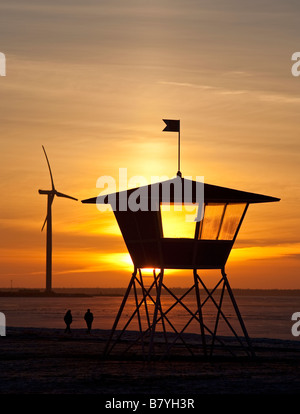 Windturbine und Rettungsschwimmer der Wachturm am Meeresufer, Finnland Stockfoto