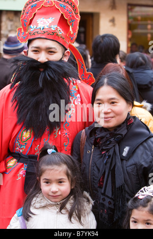 Mann in traditioneller Kleidung gekleidet potenziell als Confusious mit touristischen Familie an Chinese New Year, China Town London UK Stockfoto