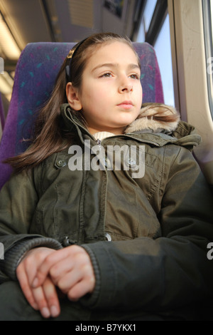 junges Mädchen sitzt auf einem Zug Stockfoto