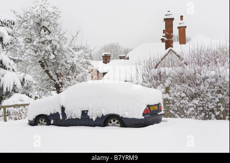 Schweren Schnee bedeckt, Autos und Häuser in einem englischen Landhaus-Dorf Stockfoto