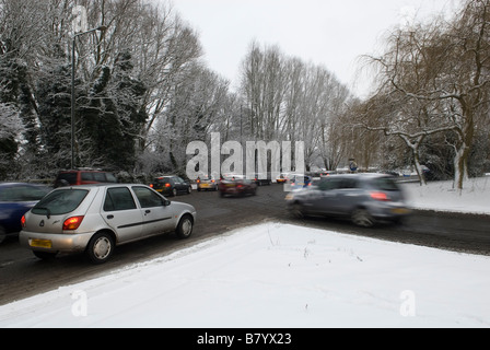 Autos, die Schlange bei eisigen Wetter in einer Coventry Straße im Winterschnee Stockfoto