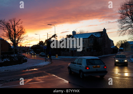 Sonnenuntergang und Reflexionen Kreisverkehr Straße Winterszene mit Schnee auf wegen Downend Bristol Stockfoto