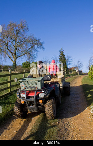 Junge Mädchen und Vater mit Quad mit Anhänger Stockfoto