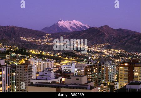 Blick über Sopocachi im Zentrum von La Paz mit dem Berg Illimani und Lichtern der Zona Sur in der Ferne bei Sonnenuntergang, Bolivien Stockfoto