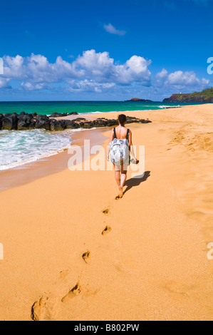 Frau zu Fuß entlang Secret Beach Kauapea Strand Insel Kauai Hawaii Stockfoto