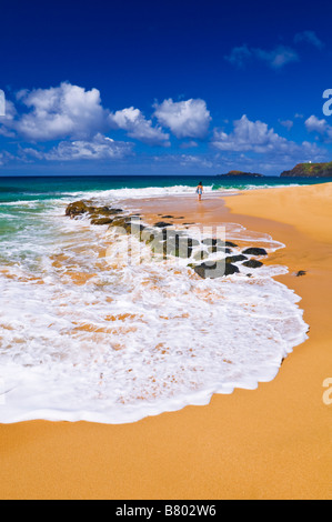 Frau zu Fuß entlang Secret Beach Kauapea Strand Insel Kauai Hawaii Stockfoto