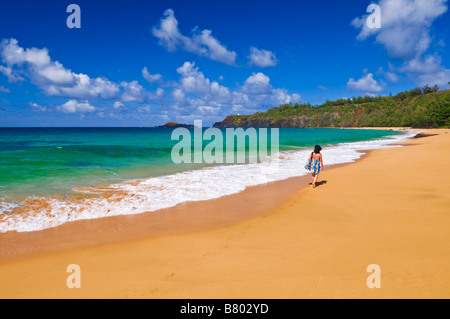 Frau zu Fuß entlang Secret Beach Kauapea Strand Insel Kauai Hawaii Stockfoto