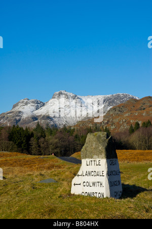 Meilenstein in der Nähe von Elterwater, Regie, entweder wenig oder Great Langdale mit Langdale Pikes in Ferne, Lake District, Cumbria Stockfoto