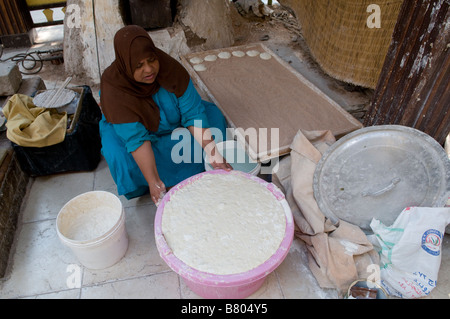 Eine Frau backen Runde gesäuertes Nahöstlichen Fladenbrot namens Khubz alternativ khoubz, khobez, khubez oder khubooz geschrieben, in Ägypten Stockfoto