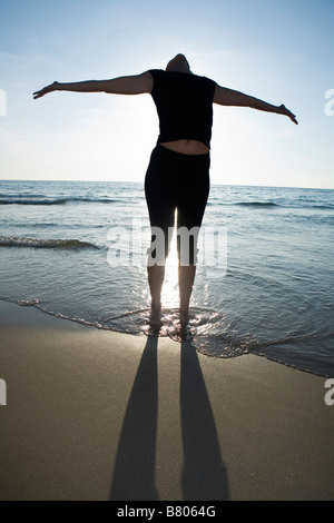 Junge Frau beim Yoga am Strand Stockfoto