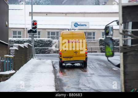 DHL-Lieferwagen auf verschneiten Straße Stockfoto