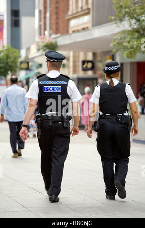 RÜCKSEITIGE ANSICHT VON ZWEI POLIZISTEN, MÄNNLICH UND WEIBLICH, AUF DER HOHEN STRAßE IN SOUTHEND ON SEA. Stockfoto