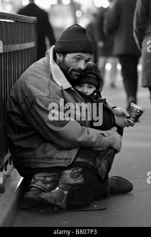 Obdachloser betteln mit ihrem Sohn auf Straßen in Paris Stockfoto