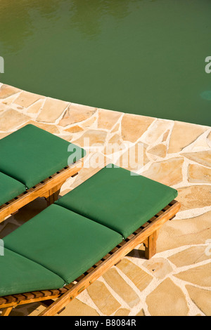 An einem nierenförmigen Pool im Urlaub Stockfoto