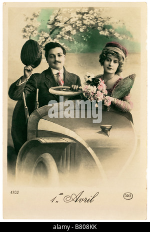 Tag des April Dummkopfs / Poisson d - frühen 1900er Jahren traditionelle französische Postkarte mit paar in altes Auto mit Frau holding Fisch Stockfoto
