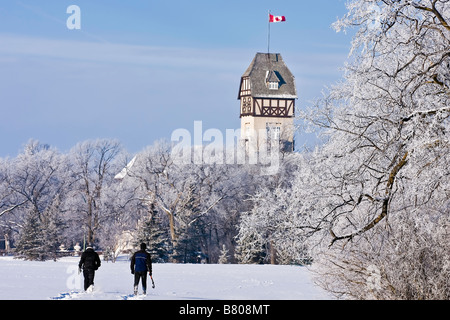 Paar, Schneeschuhwandern, bedeckt Raureif, Bäume und Pavillon in Assiniboine Park, Winnipeg, Manitoba, Kanada. Stockfoto