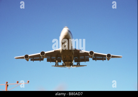 747 Düsenflugzeuge mit Klappen und Fahrwerk nach unten fliegen über Airport guide Marker wie er landet. Stockfoto