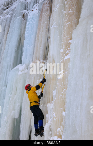 Eiskletterer nachschlagen während vorne nach oben eine steile Wand aus Eis bei Tiffany Falls Ontario Stockfoto