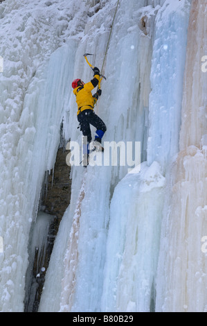 Eiskletterer Axt schwingen, während vorne nach oben einen steilen Eisfall bei Tiffany Falls Ontario Stockfoto